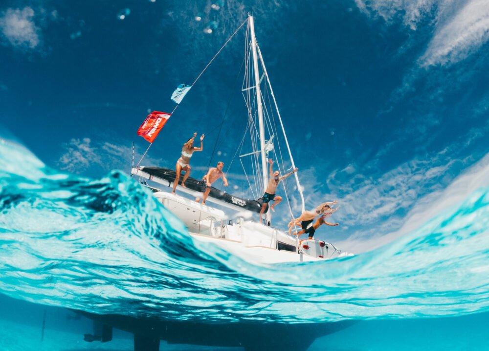 Private group of people jumping into the blue water in teh Caribbean